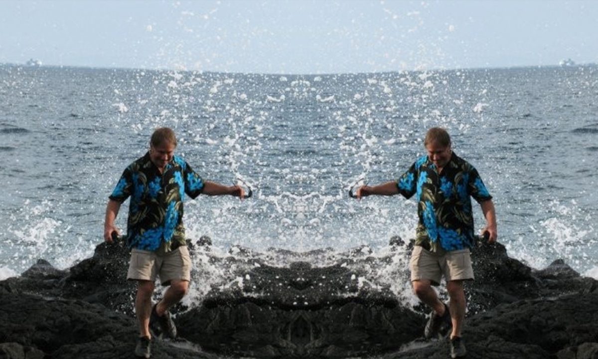 A photo of Fred Wilkins on a jetty at the beach. It is mirrored in the middle.